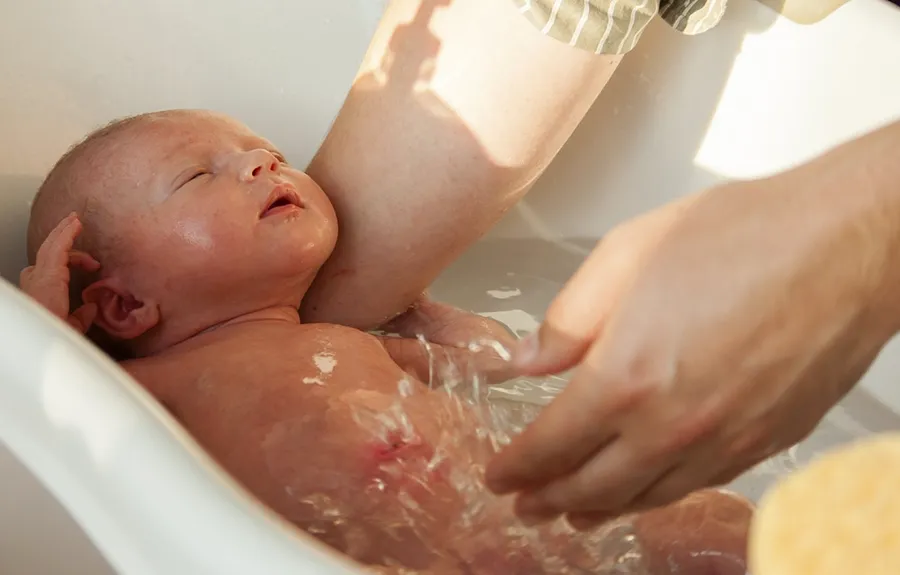 На фото Перше купання новонародженого малюка після пологового будинку